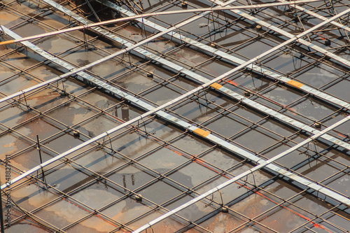 Cleaned floor slab reinforcement bar with post tension cable tendon on steel form work at the construction site before concreting. photo