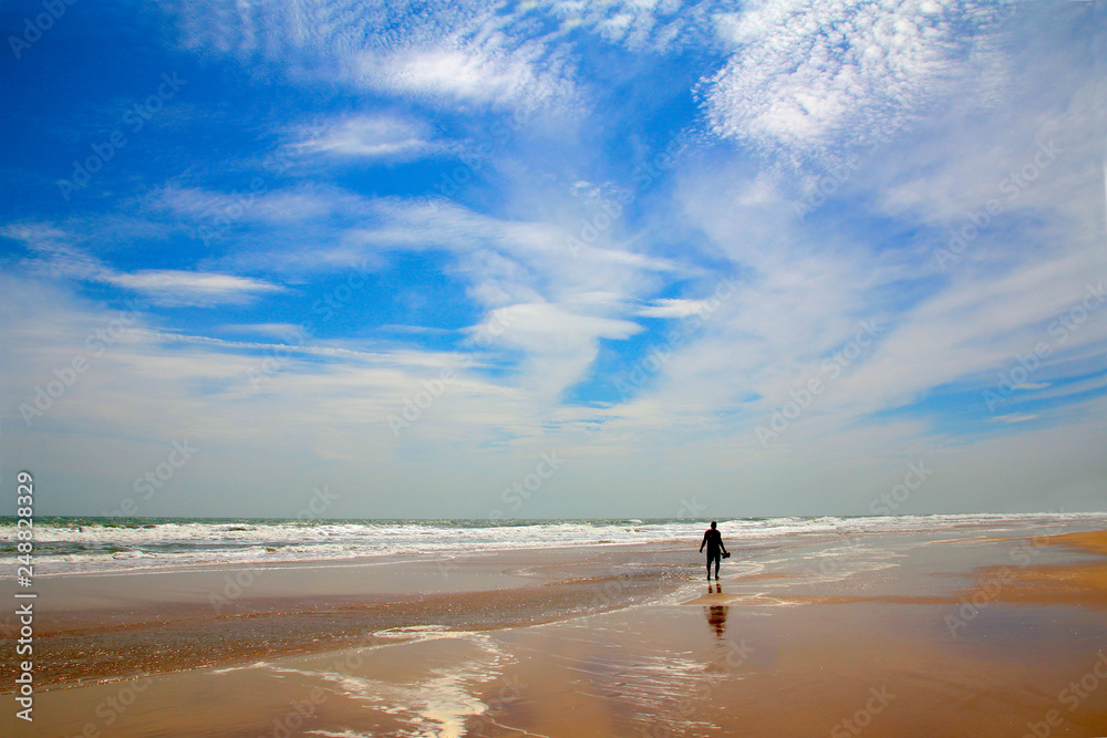 One man walks on an empty sea beach