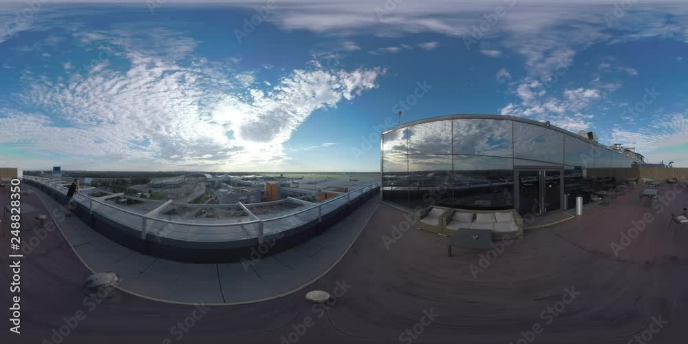 MOSCOW, RUSSIA - AUGUST 08, 2017: 360 VR video. Hotel rooftop with cafe and man (with model release) looking at road traffic and Sheremetyevo Airport with airplane taking off
