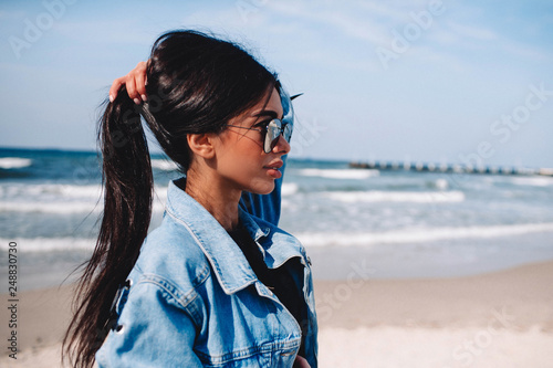 Close up portrait of beautiful young woman on the beach. Young caucasian female model on the sea shore.Great pleasure. Charming calm young woman is standing near sea with closed eyes.