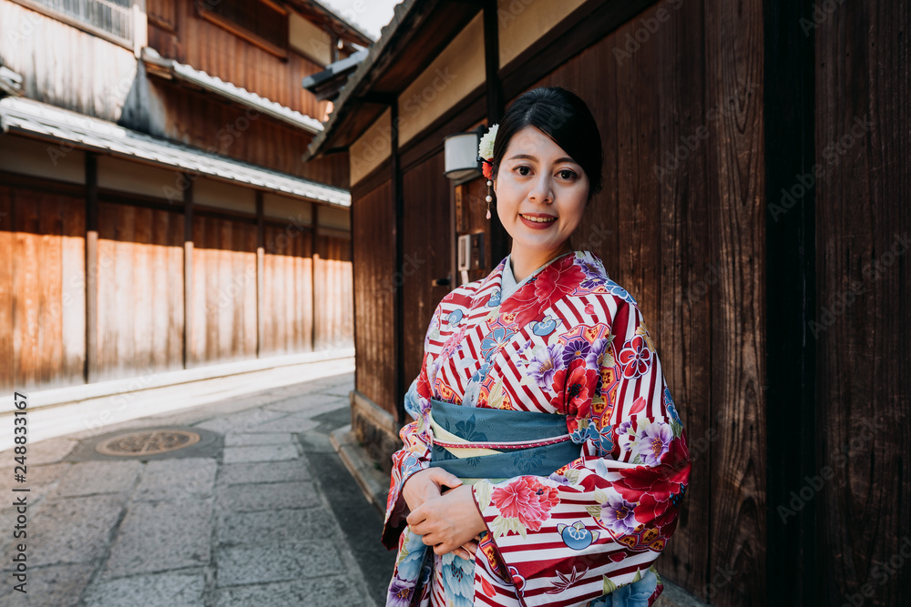 young local japanese girl pink floral kimono face camera smiling walking in ishibe alley kyoto japan in summer. woman in traditional dress relaxing near historical wooden wall house in spring. young local japanese girl pink floral kimono face camera smiling walking in ishibe alley kyoto japan in summer. woman in traditional dress relaxing near historical wooden wall house in spring.