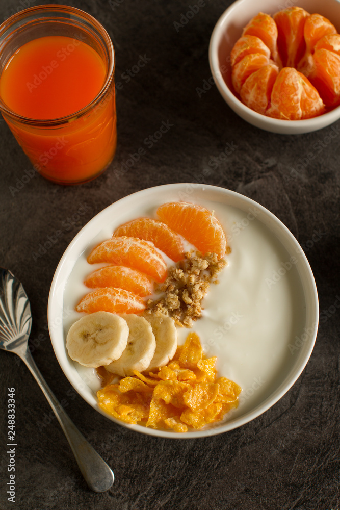 Smoothie bowl with tangerines,bananas, granola and walnuts from above Smoothie bowl with tangerines,bananas, granola and walnuts from above