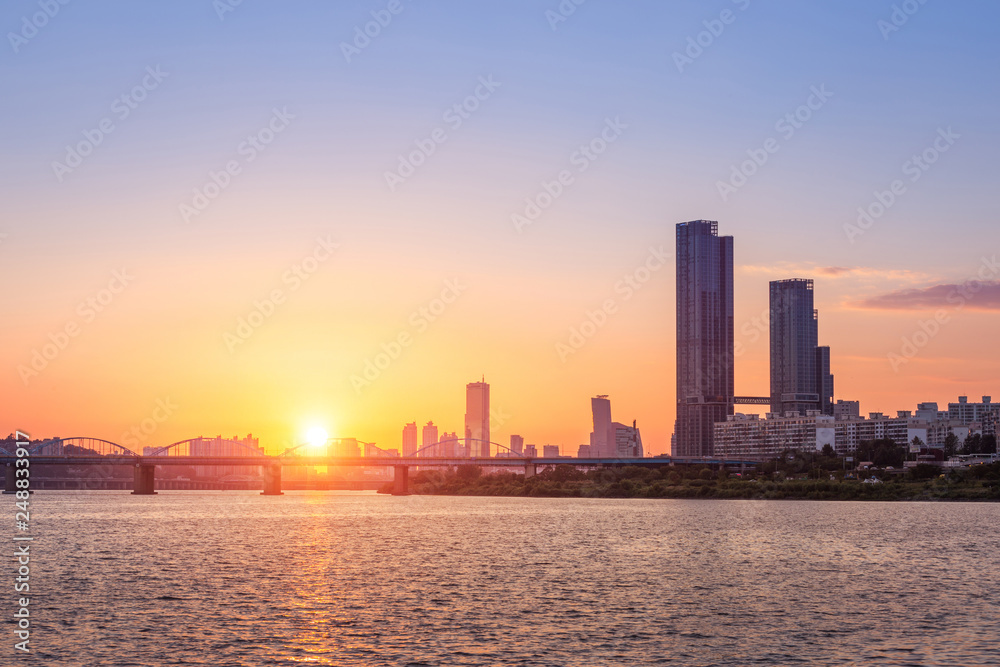 Sunsets behind the skyscrapers of yeouido and bridges across the Han River in Downtown Seoul, South Korea.