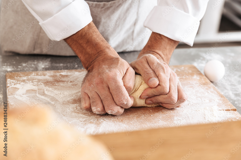 Closeup portrait of caucasian male hands mixing dough for pastry, on table at bakery or kitchen Closeup portrait of caucasian male hands mixing dough for pastry, on table at bakery or kitchen