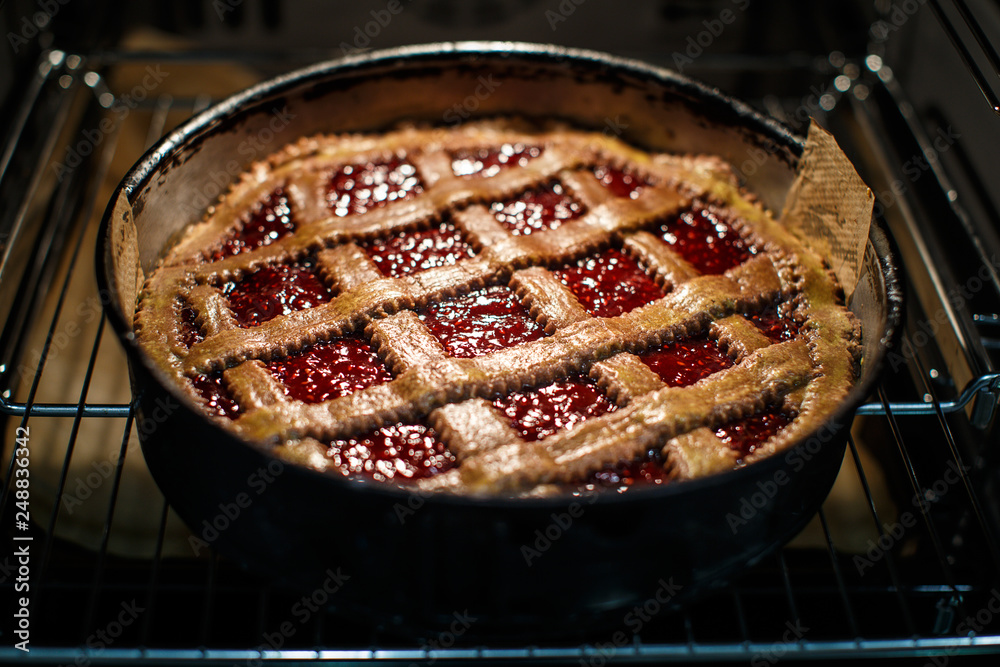 Linzer torte (christmas almond pastry with lattice design) coming out of the oven after being baked.