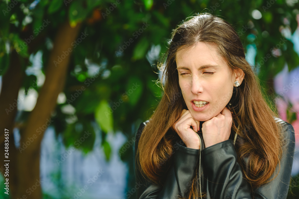 Young woman in winter with sore throat and pain gesture thinking about going to the doctor. Young woman in winter with sore throat and pain gesture thinking about going to the doctor.