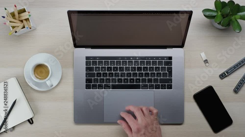 Male hands typing laptop on white clean minimalistic table with top view, gestures and finger movements