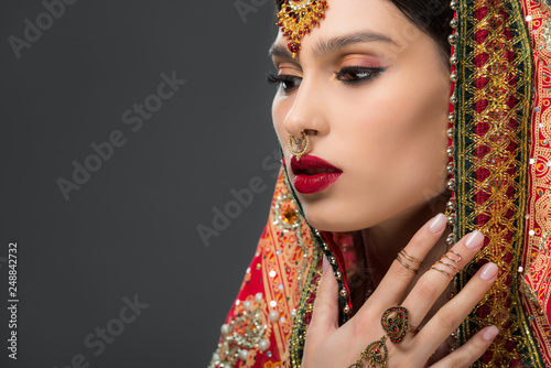 attractive indian woman posing in traditional sari, isolated on grey