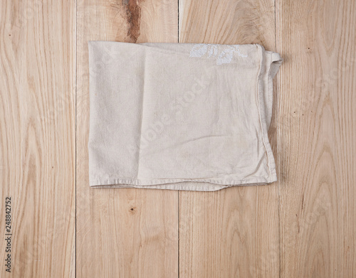 folded white towel on brown wooden background