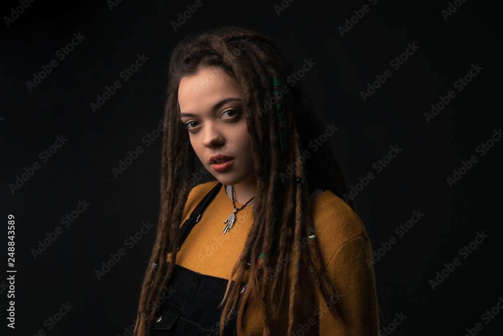 Portrait of a young girl with dreads on black background. Studio shoot. Portrait of a young girl with dreads on black background. Studio shoot.