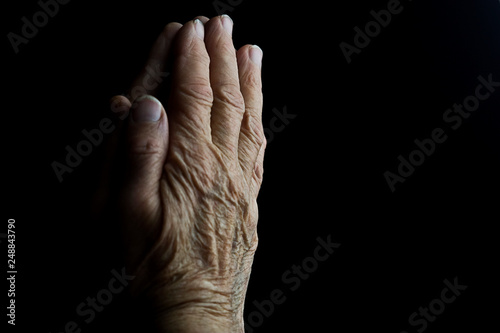 Old hands of a praying mother close up