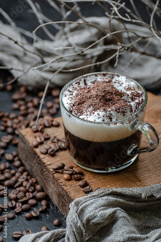 Fototapeta Naklejka Na Ścianę i Meble -  Cappuccino coffee with milk foam and chocolate closeup. Low key photography.