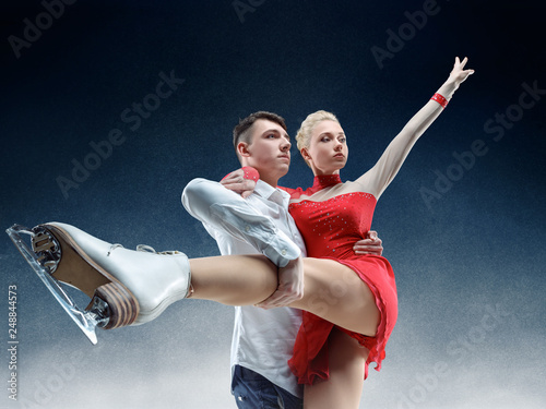 Professional man and woman figure skaters performing show or competition on ice arena photo