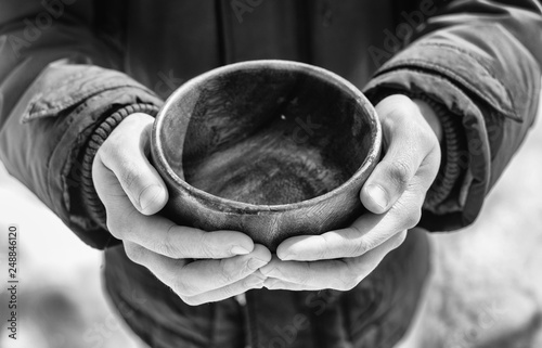 Men hand holding empty wooden bowl. Black and white.