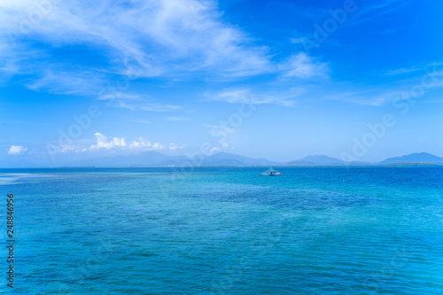 Beautiful ocean scene view isolated with light blue sky background, concept of vacation and sea travel, copy space