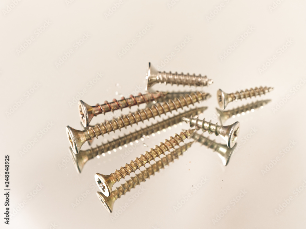 yellow hardware screws on a white background yellow hardware screws on a white background
