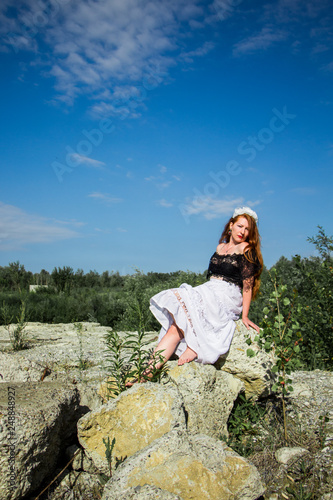 Young redhead girl sitting on the rock  © Julia