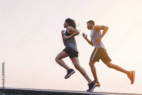 Obraz na plátně young couple runner running on running road in city park