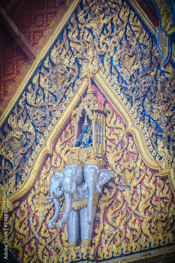 Beautiful sculpture of angel riding three heads elephant on the gable end of the buddhist church in Thai temple.