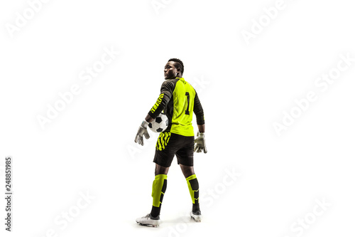One african male soccer player goalkeeper standing and holding ball. Silhouette isolated on white studio background