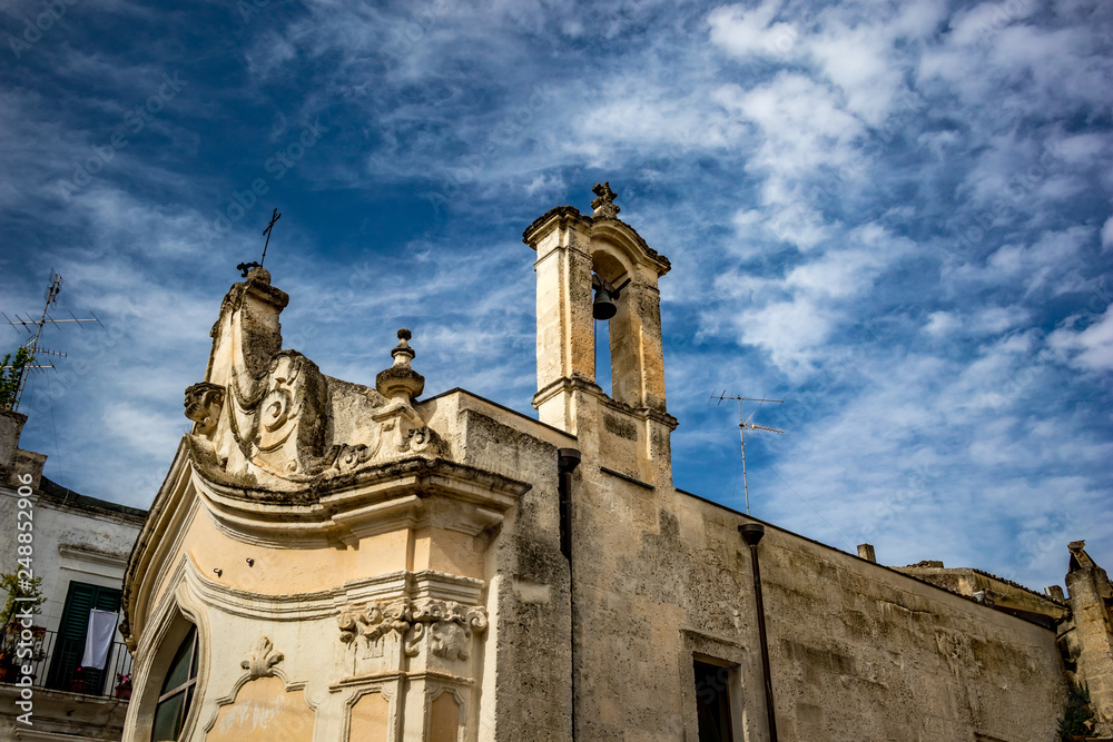 The amazing medieval Church of Madonna dei Martiri in the stunning town of Altamura in the Puglia region, South Italy. Close-up street detail view. Lovely sunny summer day with puffy white clouds