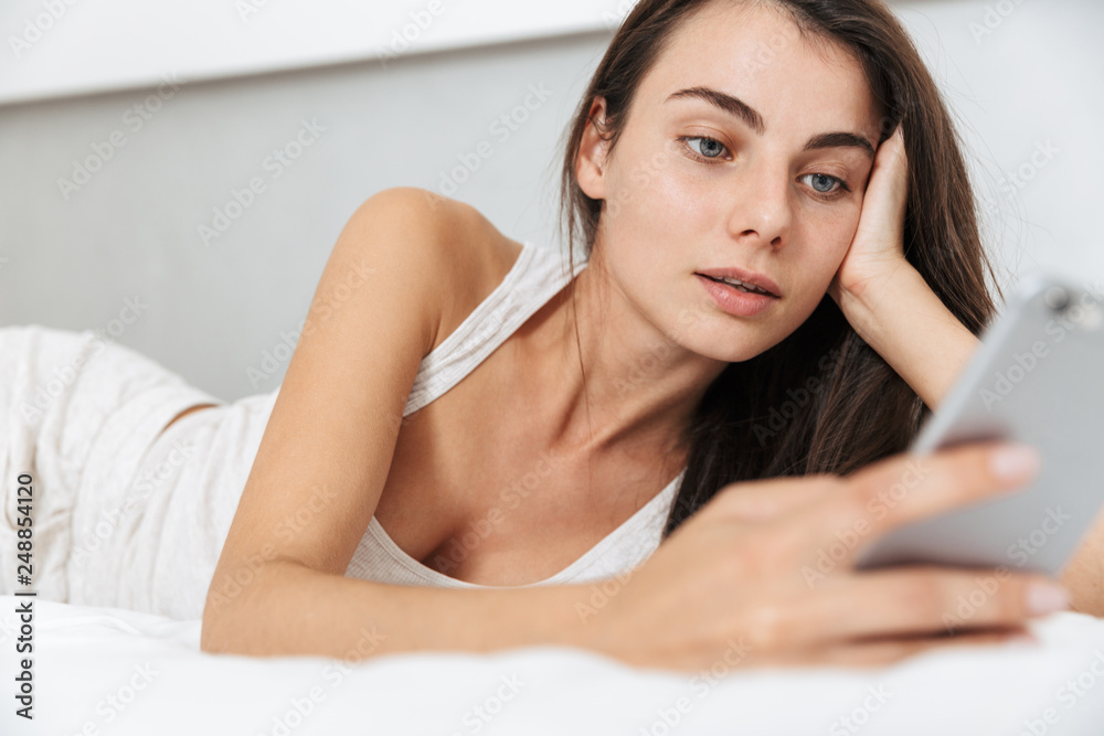 Fototapeta premium Beautiful young woman relaxing on bed at home