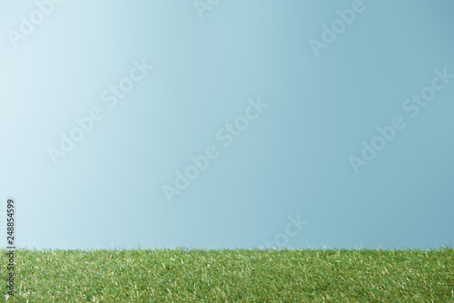 fresh bright green grass on blue background with copy space
