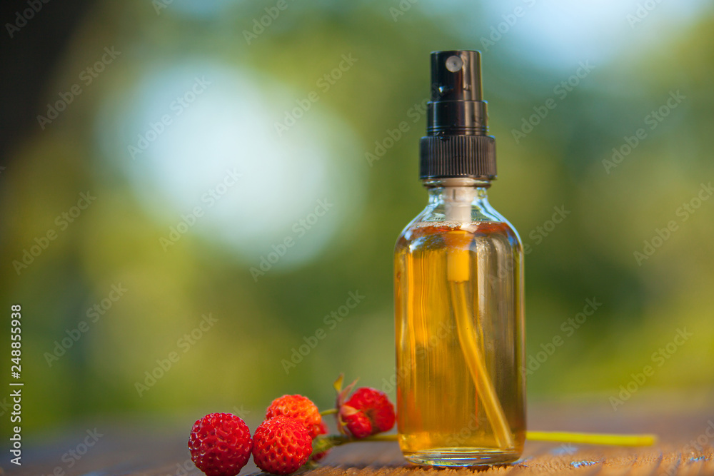 Essence of Wild strawberry on table in beautiful glass jar