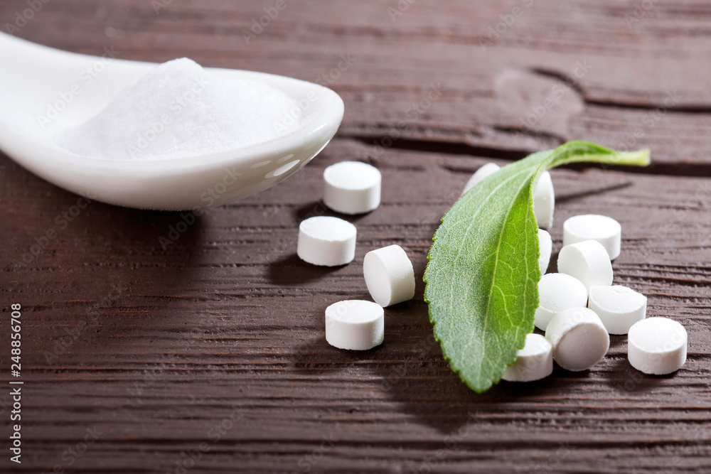 Pills, powder and leaves of stevia plant - Stevia rebaudiana. Wood background Pills, powder and leaves of stevia plant - Stevia rebaudiana. Wood background