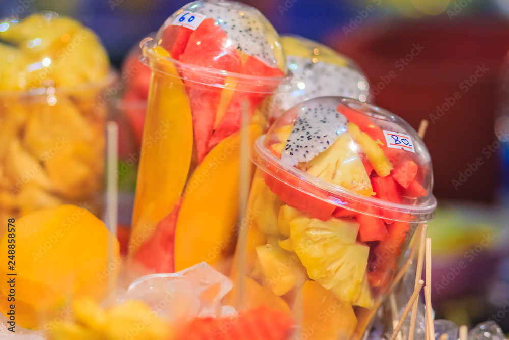 Fruit salad arranged in plastic cups for sale on street at Bangkok night market, Thailand.