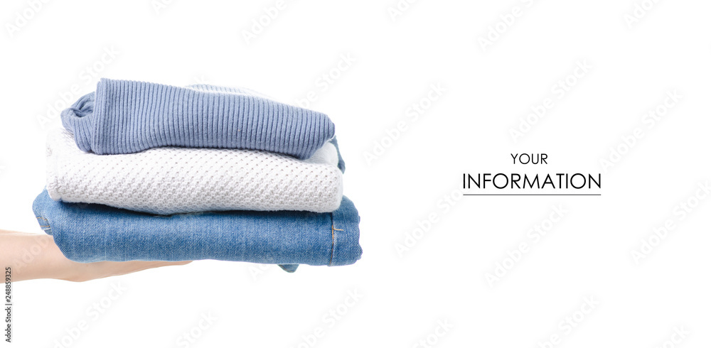 Fototapeta premium Stack of clothing jeans sweaters in hand pattern on a white background isolation