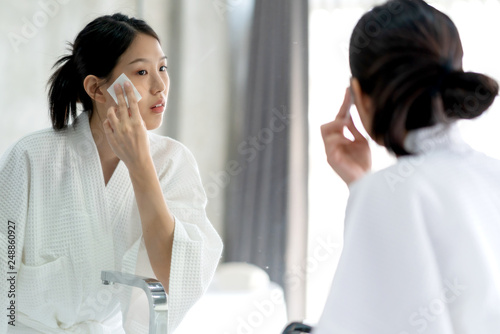 beautiful asian woman bare skin in white bathrobe wash and clean facial with care in morning freshness sunlight