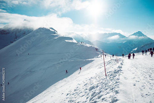 Fototapeta Naklejka Na Ścianę i Meble -  People enjoying beautiful weather in snow covered mountains