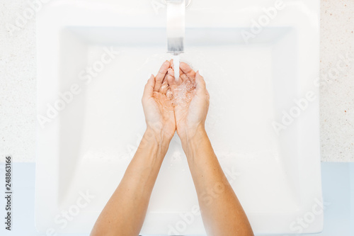 Woman washing hands in washroom photo