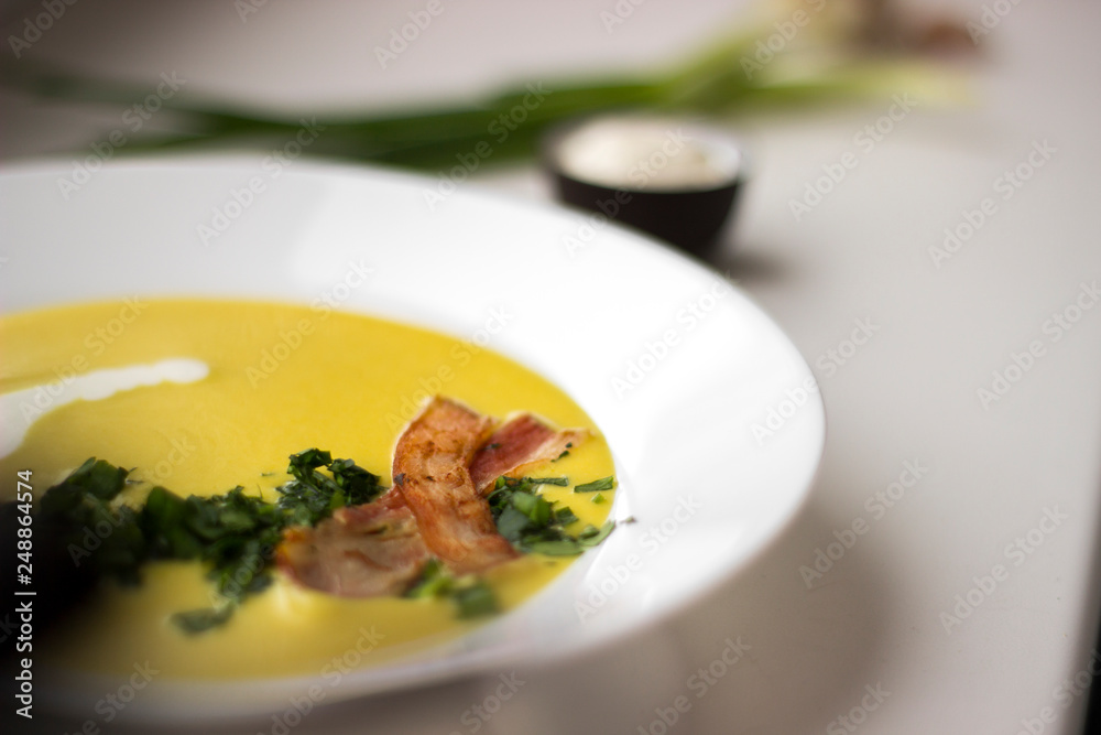 Pea soup with pieces of bacon, parsley and onion in a bowl on a white background macro. Pea cream soup. Pea soup with pieces of bacon, parsley and onion in a bowl on a white background macro. Pea cream soup.