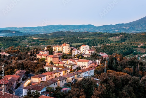 Chiusi village vintage cityscape at sunrise in Umbria Italy with streets and rooftop houses on mountain countryside and rolling hills with brown foliage trees