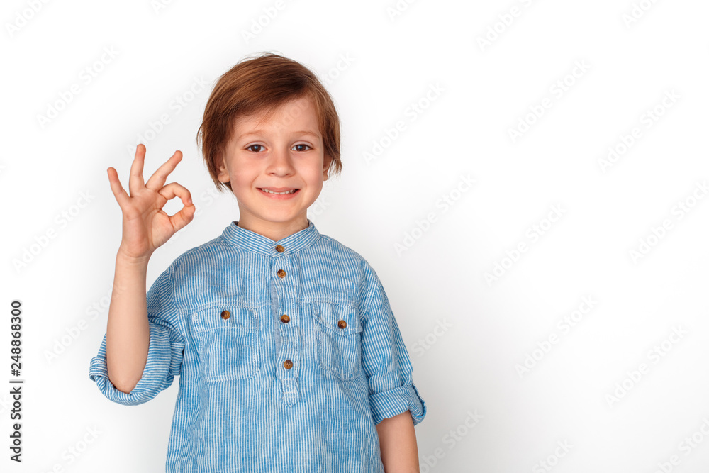 Boy studio standing isolated on grey showing ok looking camera positive Boy studio standing isolated on grey showing ok looking camera positive