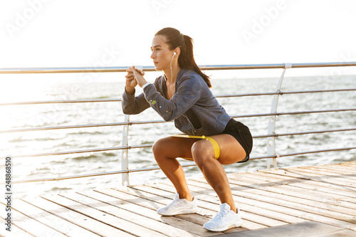 Concentrated sportswoman doing exercises with a rubber band