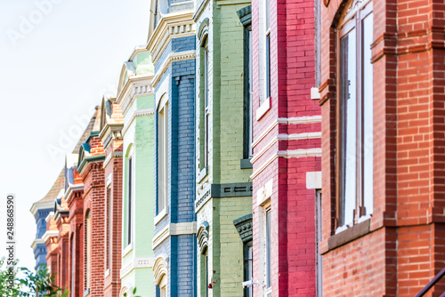 Row of colorful red green and blue painted brick residential townhouses homes houses architecture exterior in Washington DC Capitol Hill neighborhood district