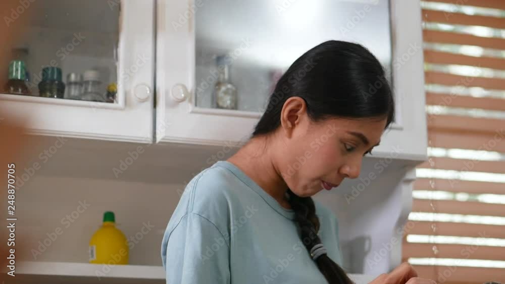 Young asian woman using tablet and eating bread. technology, social network, communication concept in kitchen at home. Young asian woman using tablet and eating bread. technology, social network, communication concept in kitchen at home.