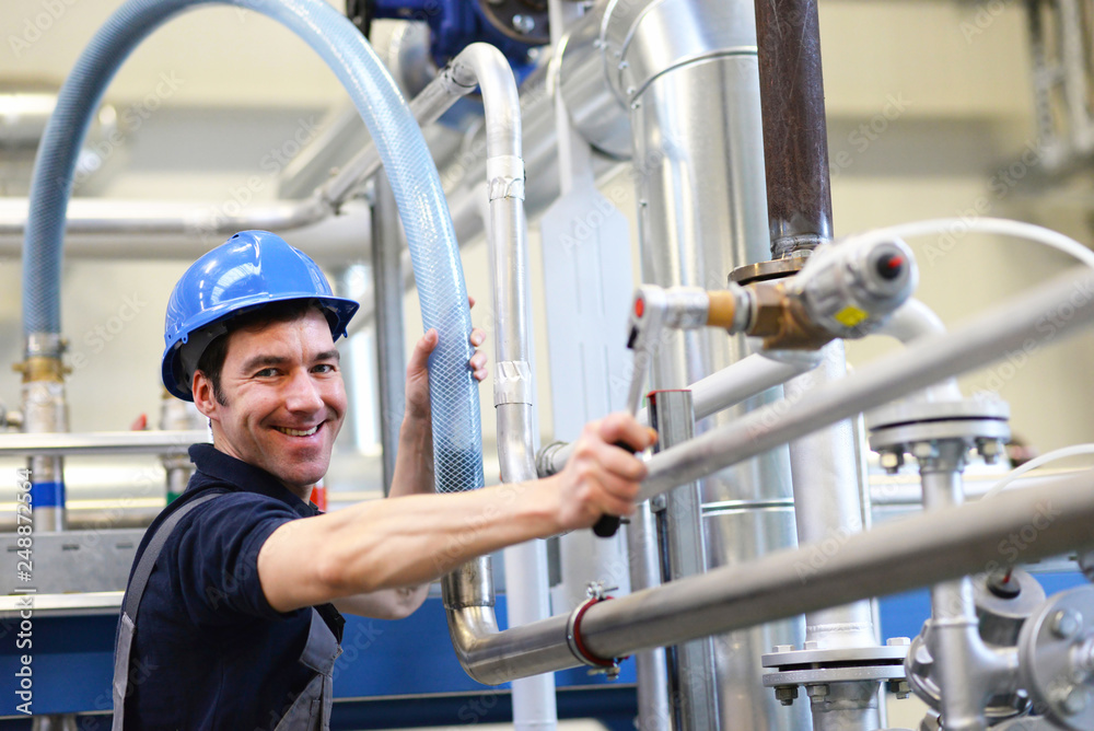 Industriemechaniker repariert eine technische Anlage // Industrial mechanic repairs a technical system Industriemechaniker repariert eine technische Anlage // Industrial mechanic repairs a technical system