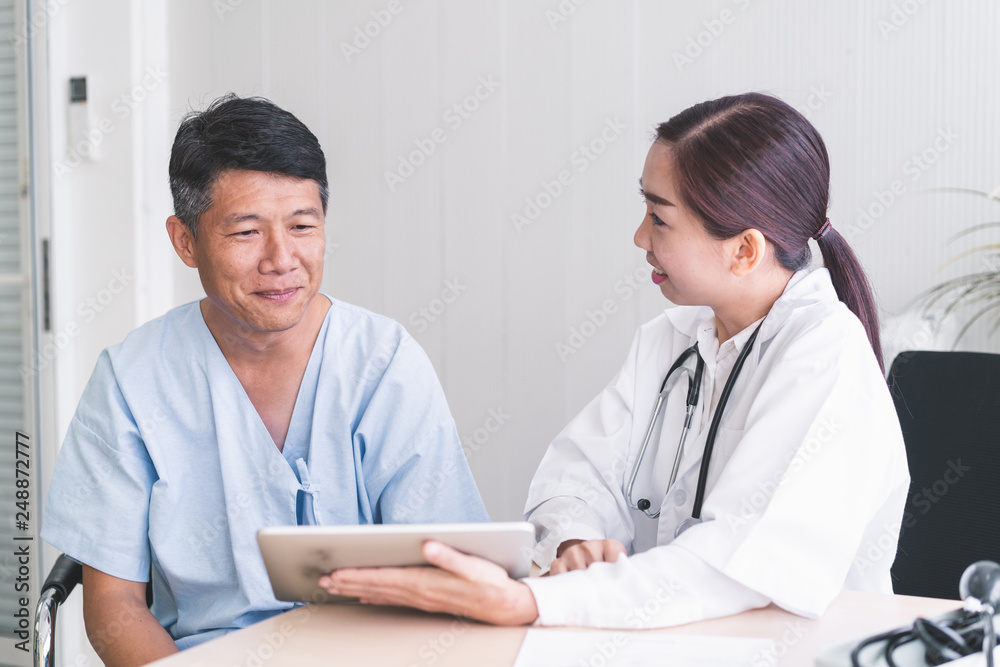Woman doctors are explaining something from a tablet to a sick male patient. Woman doctors are explaining something from a tablet to a sick male patient.