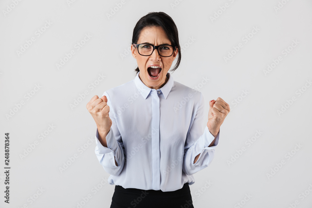Image of excited secretary woman wearing eyeglasses standing in the office, isolated over white background Image of excited secretary woman wearing eyeglasses standing in the office, isolated over white background