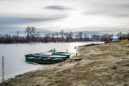 Forgotten boat in frozen lake water