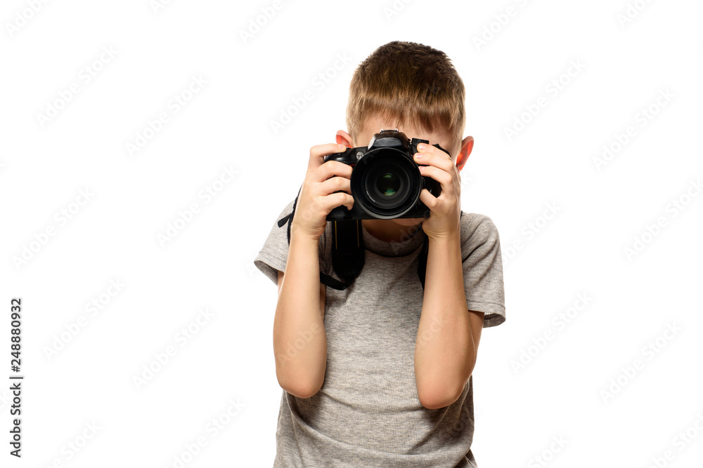 Boy takes pictures on the camera. Portrait. Isolate on white background Boy takes pictures on the camera. Portrait. Isolate on white background