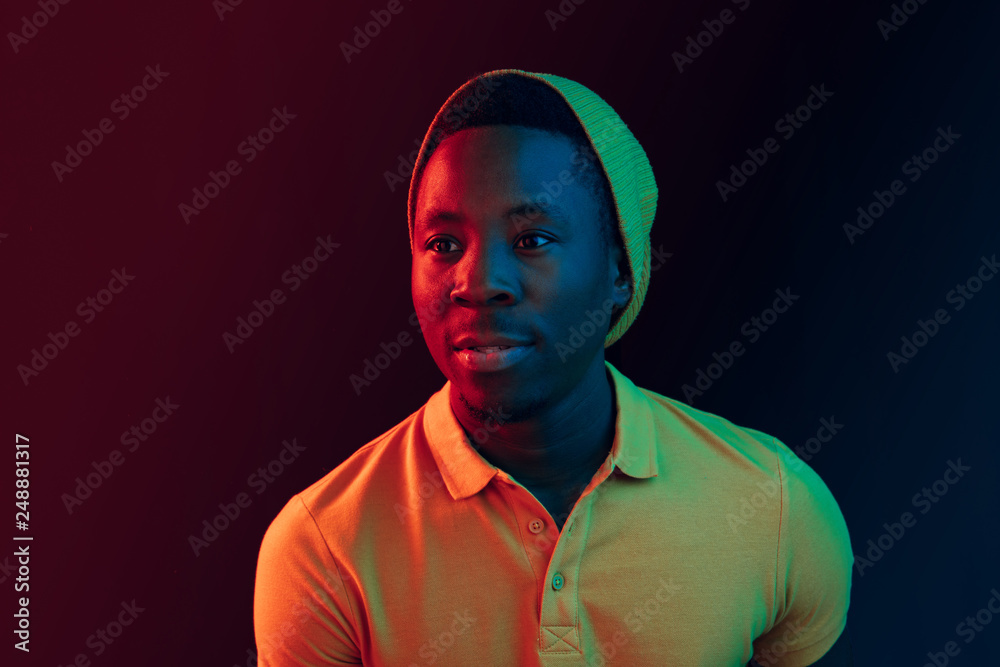 Close up portrait of a happy young african american man smiling on black neon studio background Close up portrait of a happy young african american man smiling on black neon studio background