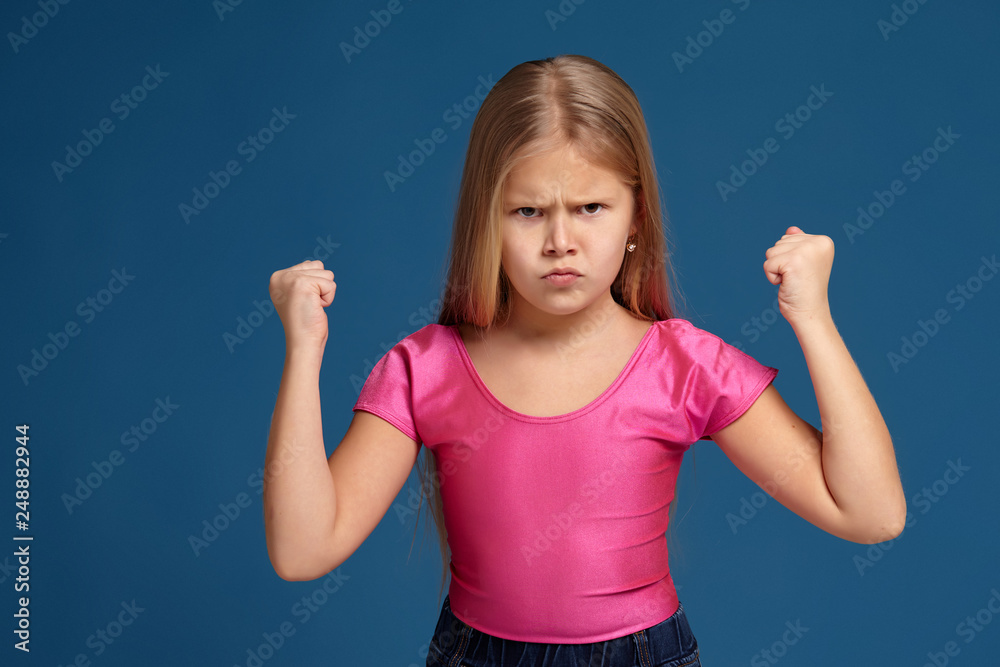 Fototapeta premium Portrait of emotional little girl on blue background