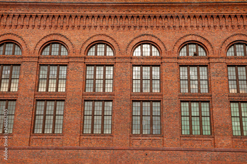 Large windows on the side of a historic red bricked building