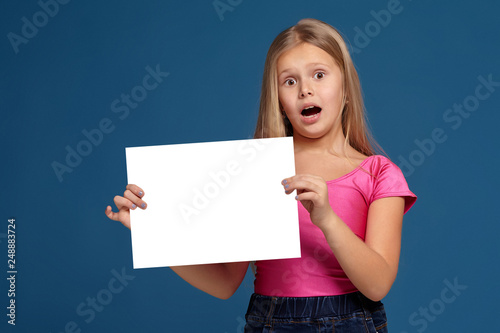 Portrait of adorable emotional little girl on blue background
