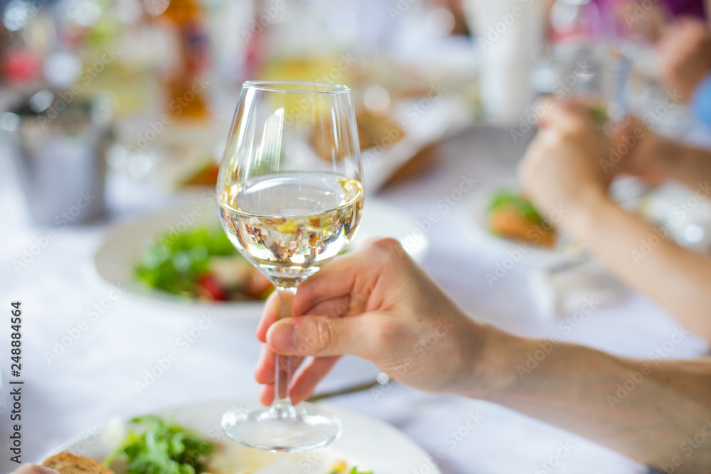 Obraz premium hands holding a glass of red wine